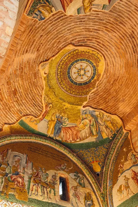 Bare brick vault with surviving patches of gold mosaic, and a lunette below showing an enthroned ruler with soldiers