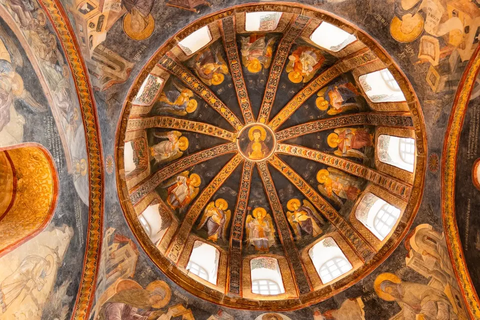 View straight up into a ribbed dome with a medallion of the Virgin and Child at the centre and an angel in each segment